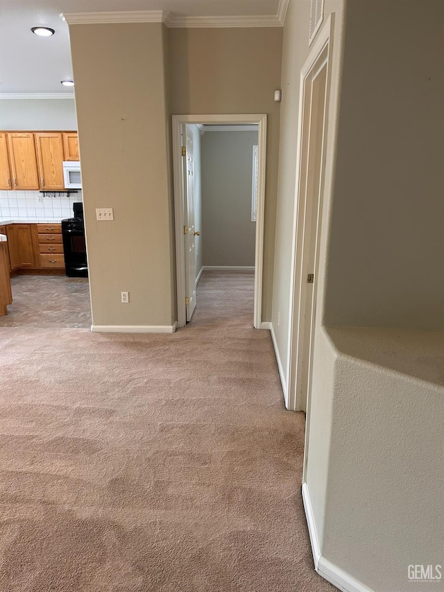 hallway with ornamental molding and light colored carpet
