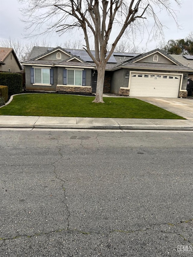 ranch-style home featuring a garage and a front lawn