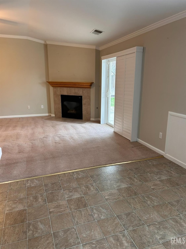 unfurnished living room with ornamental molding, a fireplace, and carpet
