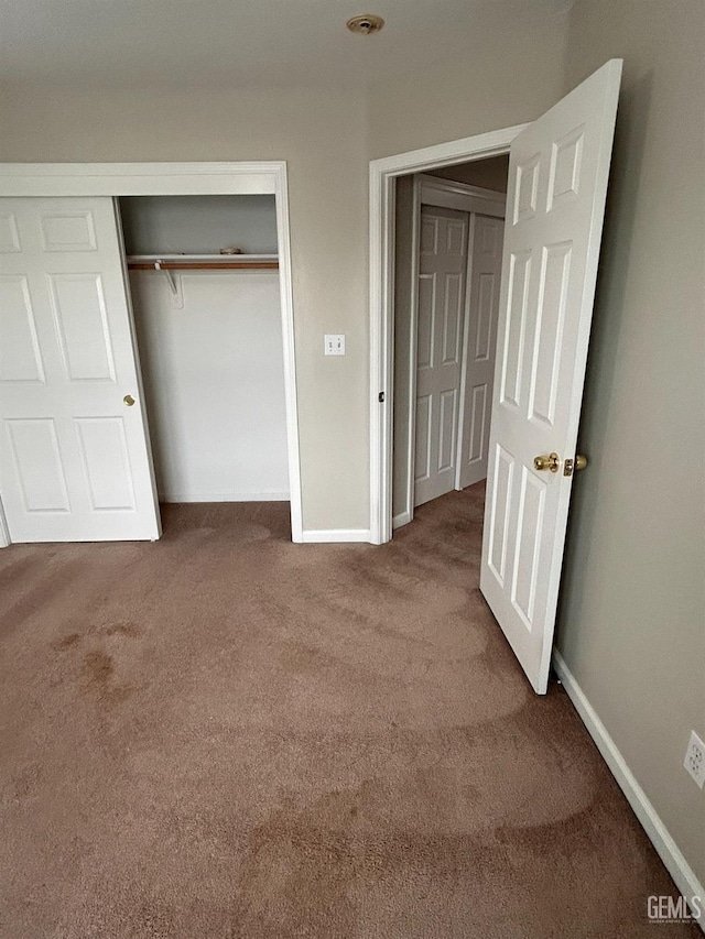 unfurnished bedroom featuring carpet and a closet