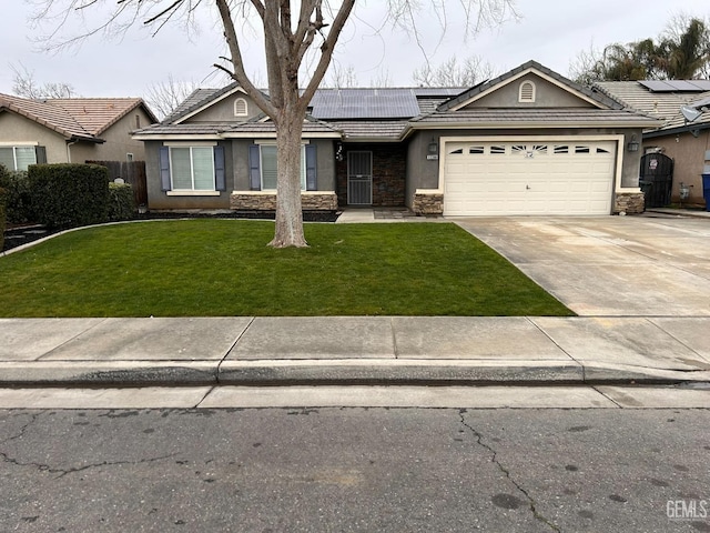 ranch-style house featuring a garage, a front yard, and solar panels