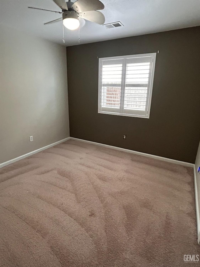 carpeted spare room with ceiling fan