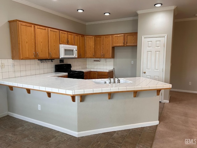 kitchen with sink, a breakfast bar area, tile counters, black range, and kitchen peninsula