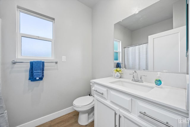 bathroom featuring hardwood / wood-style floors, vanity, toilet, and a healthy amount of sunlight