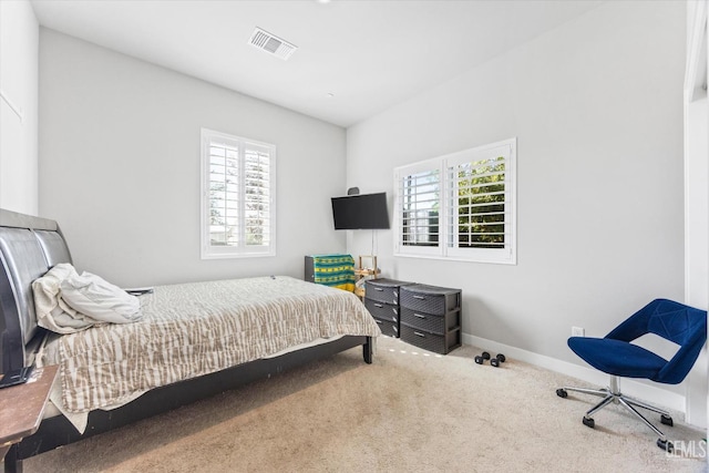 carpeted bedroom featuring multiple windows