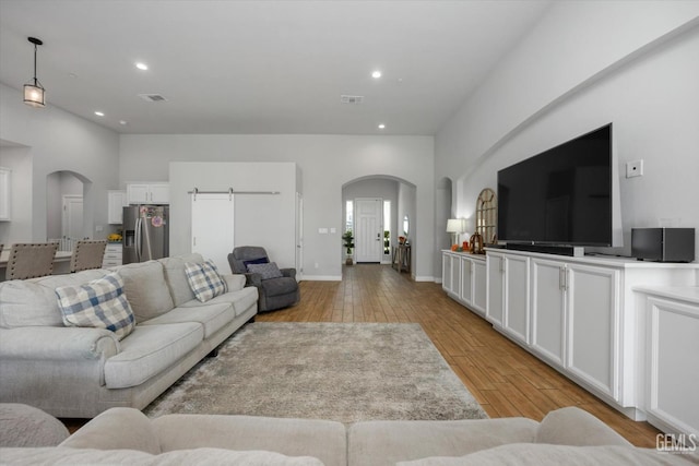 living room featuring a barn door and light wood-type flooring