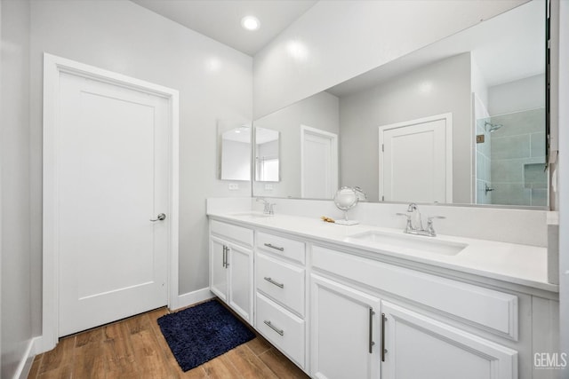 bathroom with a shower, vanity, and wood-type flooring