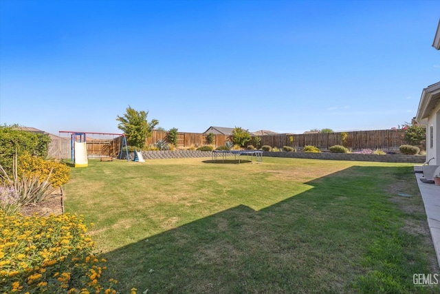 view of yard featuring a playground and a trampoline