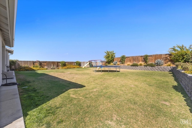 view of yard featuring a playground and a trampoline