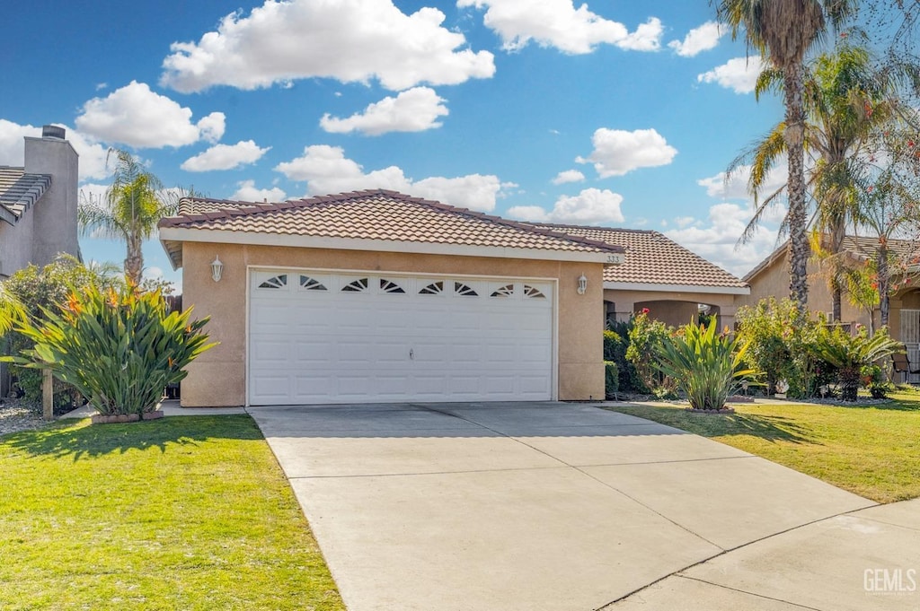 mediterranean / spanish home featuring a front yard and a garage