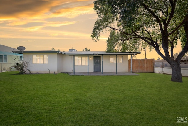 rear view of house featuring a yard, a patio area, and fence