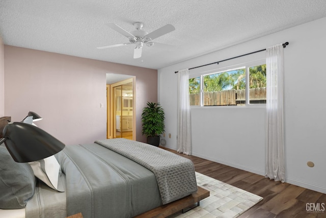 bedroom with wood finished floors, a textured ceiling, a ceiling fan, and baseboards