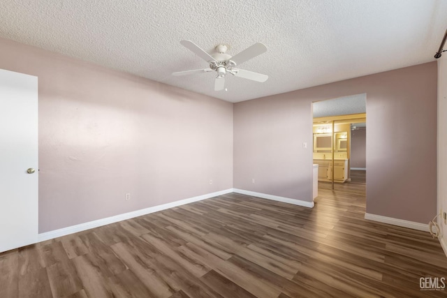 spare room with ceiling fan, wood finished floors, a textured ceiling, and baseboards