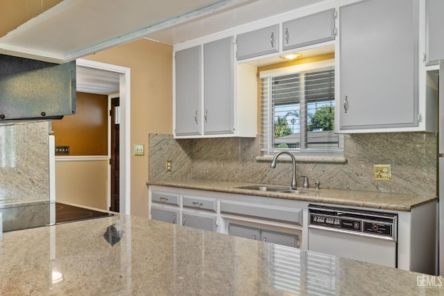 kitchen with dishwasher, a sink, black electric stovetop, backsplash, and gray cabinetry