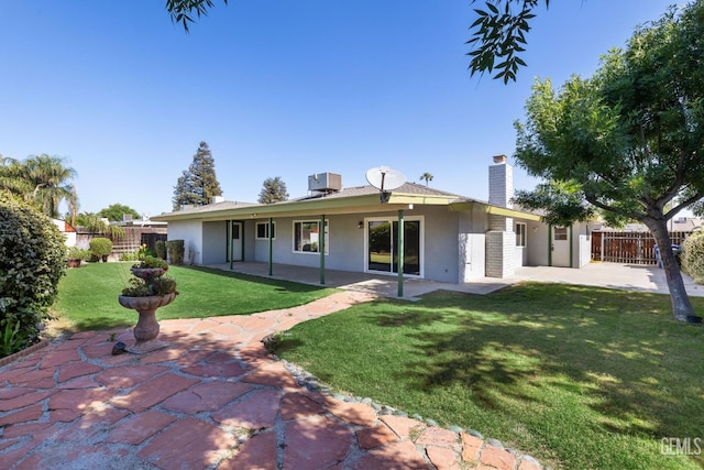 rear view of property with a patio, stucco siding, a chimney, and central air condition unit