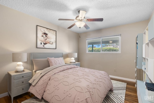 bedroom with dark wood-style floors, a textured ceiling, baseboards, and a ceiling fan