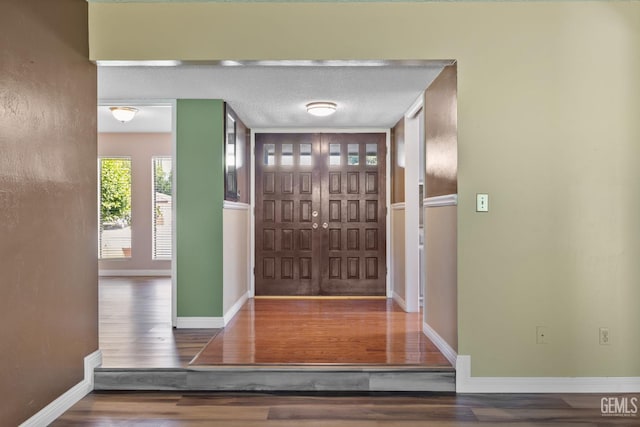 foyer entrance featuring wood finished floors and baseboards
