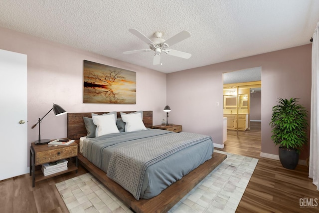 bedroom with light wood finished floors, a textured ceiling, a ceiling fan, and baseboards