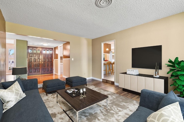 living room featuring a textured ceiling and wood finished floors