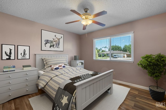 bedroom with dark wood-style floors, baseboards, a textured ceiling, and ceiling fan