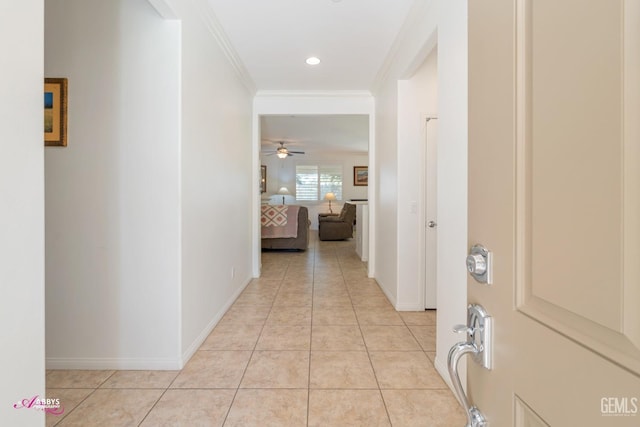 hall featuring crown molding and light tile patterned flooring