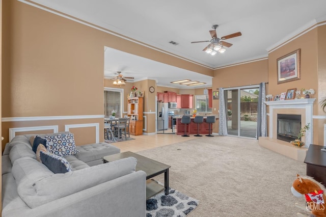 living room with light carpet, ceiling fan, and ornamental molding