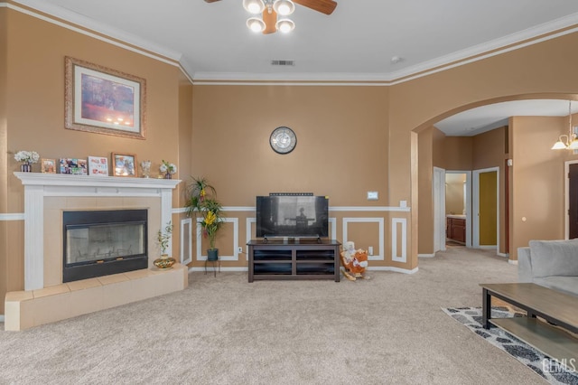 carpeted living room featuring a fireplace, ceiling fan, and ornamental molding