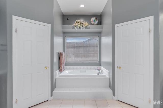 bathroom with tile patterned flooring and a relaxing tiled tub