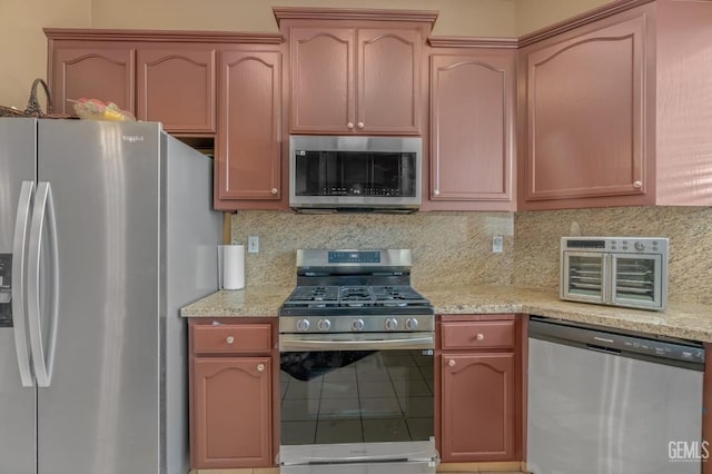 kitchen with backsplash, light stone counters, and stainless steel appliances