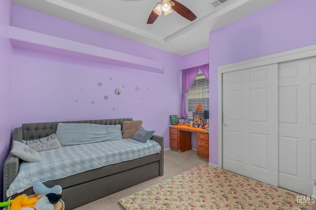 carpeted bedroom with ceiling fan and a closet