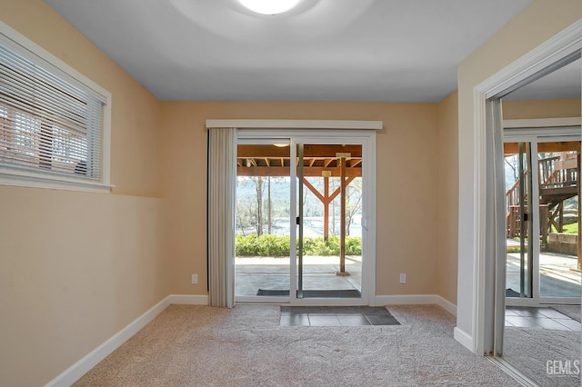 doorway to outside featuring light carpet and plenty of natural light