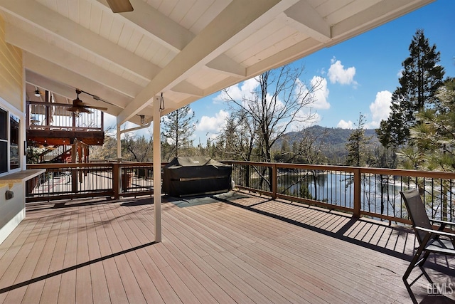 wooden terrace featuring ceiling fan, a grill, and a water and mountain view