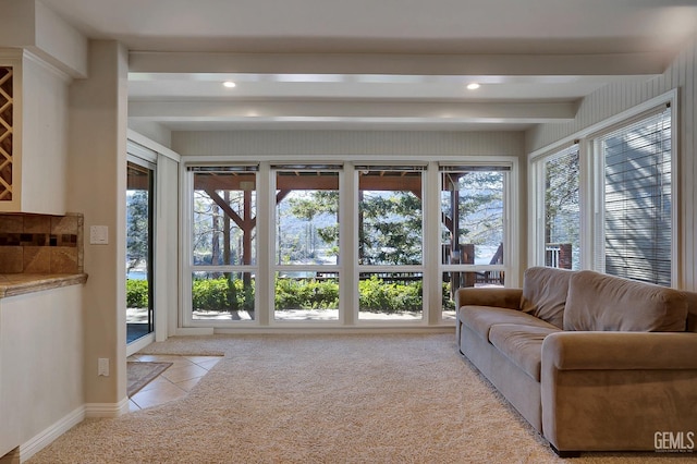 unfurnished living room with beamed ceiling and light colored carpet