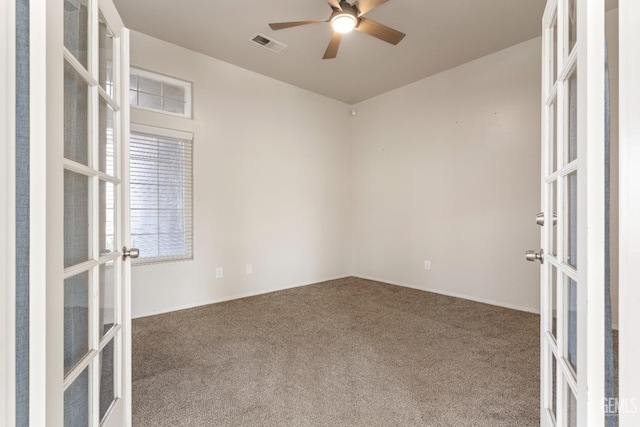 carpeted spare room with french doors, visible vents, and a ceiling fan