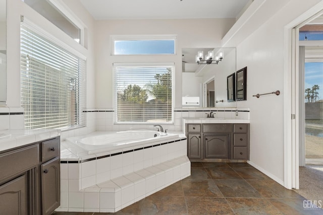 full bath with a garden tub, vanity, and baseboards