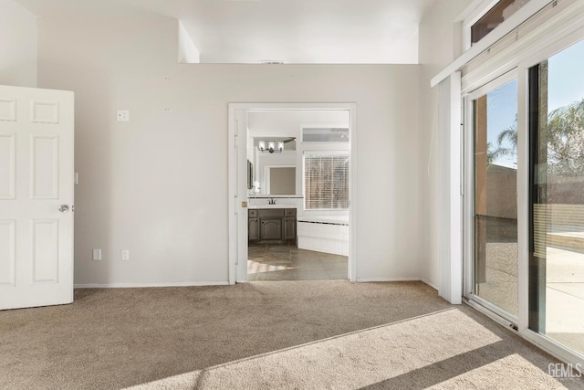 carpeted empty room featuring baseboards