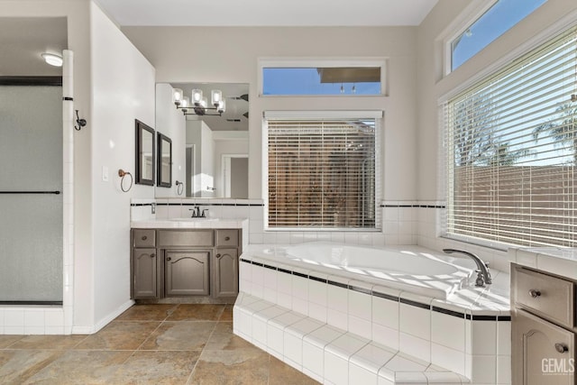 bathroom with a shower, vanity, and a bath