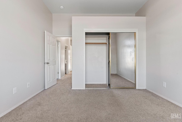 unfurnished bedroom featuring carpet, a closet, and baseboards