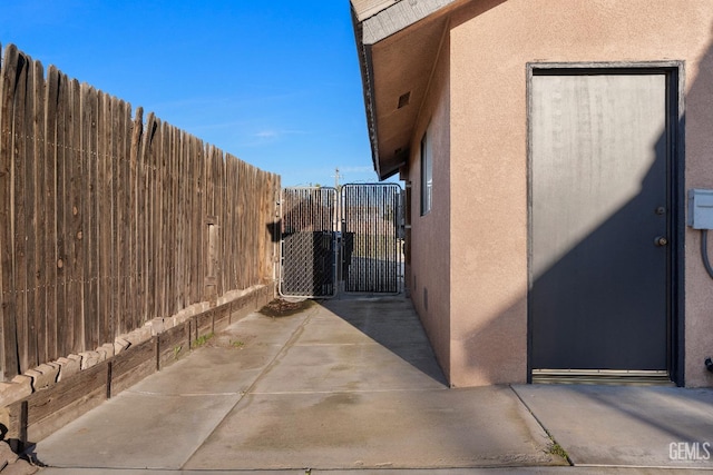 view of home's exterior with fence, a gate, and stucco siding