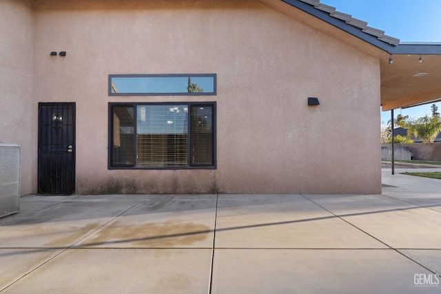 rear view of property featuring a patio area and stucco siding