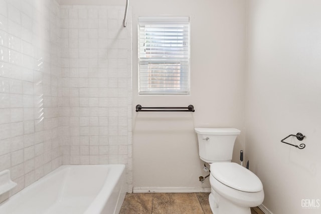 bathroom featuring baseboards, shower / tub combination, and toilet