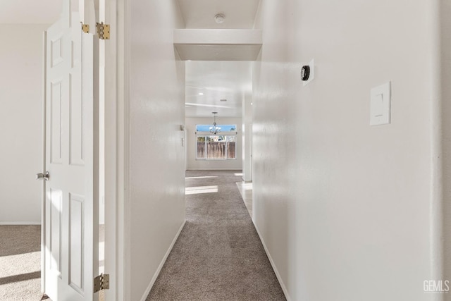 corridor with carpet floors and baseboards