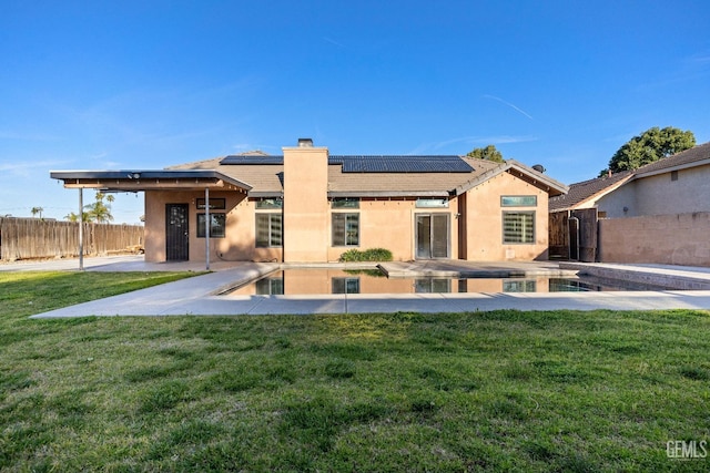 back of house with a fenced in pool, a yard, a patio, a chimney, and a fenced backyard