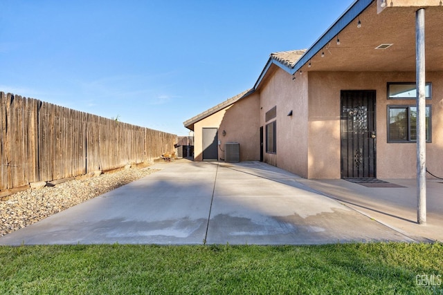 view of home's exterior with a patio area, a fenced backyard, central AC, and stucco siding