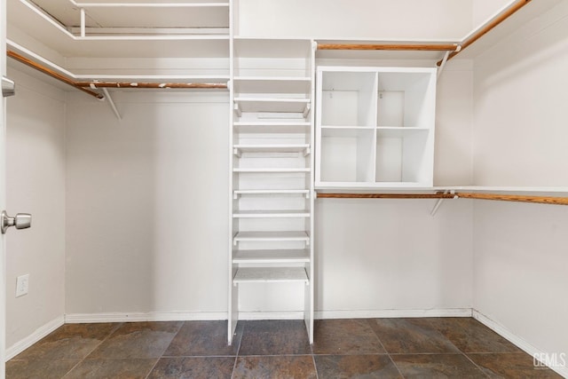 spacious closet featuring stone finish flooring