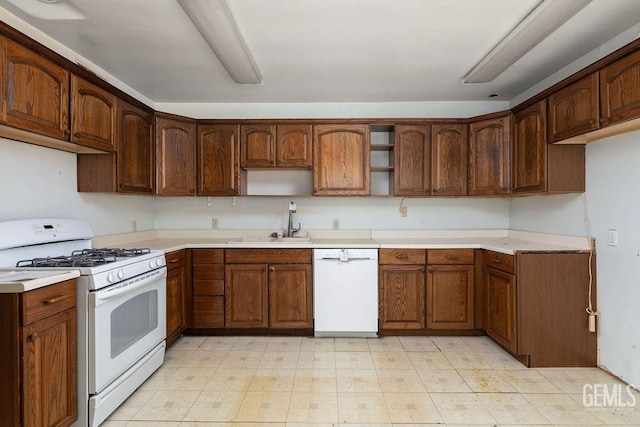 kitchen featuring open shelves, white appliances, light countertops, and a sink