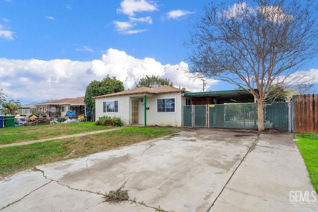 view of front of property with stucco siding, concrete driveway, a front yard, and fence