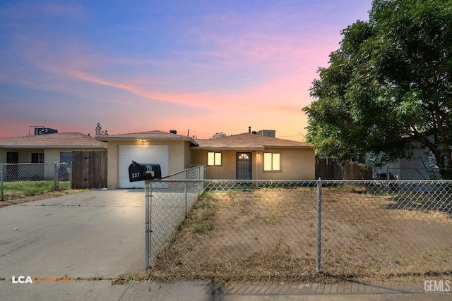 ranch-style house featuring driveway, a garage, stucco siding, and a fenced front yard