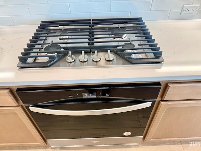 details with black dishwasher, light brown cabinetry, and stainless steel gas cooktop