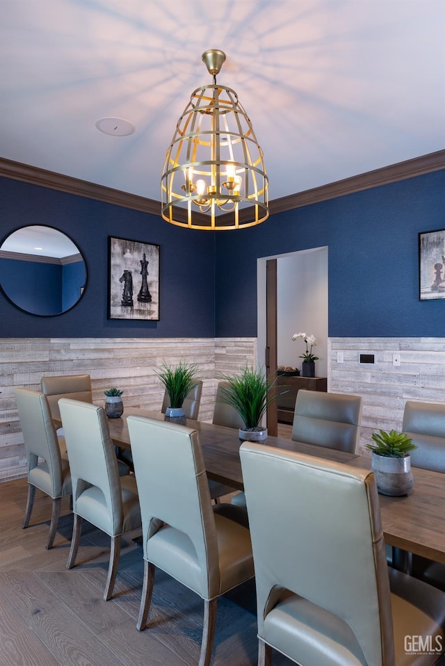 dining room with a notable chandelier, ornamental molding, and hardwood / wood-style floors